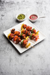 Barbecue or tandoori Mushroom Tikka, served in a plate with green chutney and ketchup. selective focus
