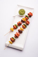 Barbecue or tandoori Mushroom Tikka, served in a plate with green chutney and ketchup. selective focus