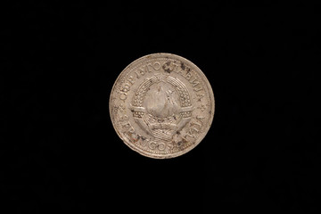 Socialist Federal Republic of Yugoslavia old stained 1 Dinar coin from 1976, obverse showing the state emblem of Yugoslavia. Isolated on black background