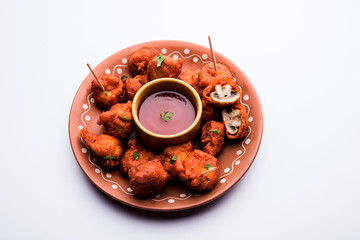 Mushroom 65, starter or appetiser food recipe from India. served in a plate with ketchup. selective focus