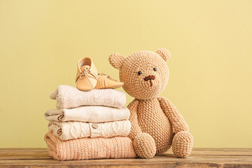 Stack of baby clothes and toy on table