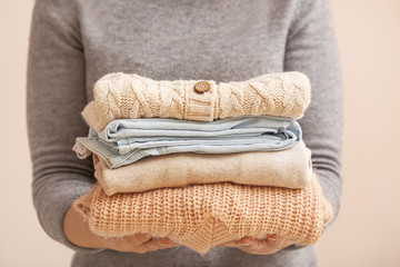 Woman with stack of warm clothes, closeup