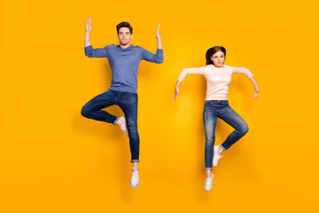 Fototapeta na wymiar Full length photo of serious team married couple jump raise hands dance like humanoid robots wear stylish modern clothes isolated over bright color background