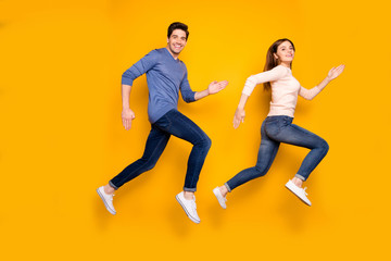 Fototapeta na wymiar Full size profile side photo of funky two married people jump run after summer black friday bargains wear blue pink pullover denim jeans sneakers isolated over bright color background