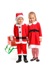 Cute little children in Santa costumes and with Christmas gifts on white background