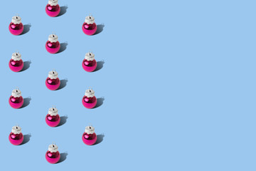 Pink baubles Christmas decoration pattern on pastel blue background minimal creative holiday concept.