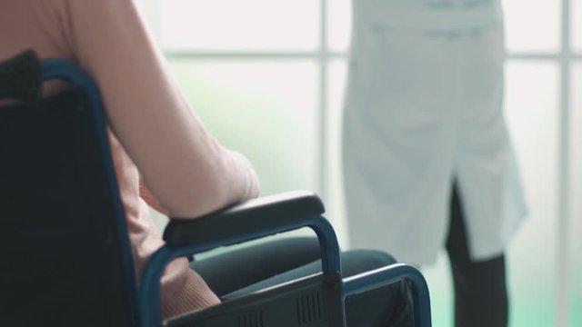 Doctor checking a radiography of a patient in wheelchair