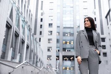 Portrait of beautiful woman in stylish suit on city street. Space for text