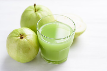 Green guava fruit and guava juice in glass on white background, high vitamin C healthy drink