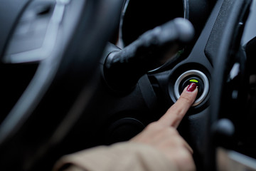 a girl starting the car engine with the start stop button