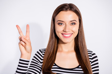 Close up photo of lovely lady making v-sign with toothy smile wearing striped pullover isolated over white background