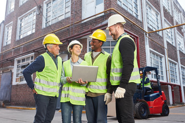 Logistik Team mit Laptop Computer vor Depot