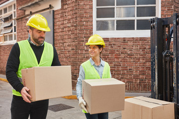 Zwei Logistik Arbeiter tragen zusammen Pakete - obrazy, fototapety, plakaty