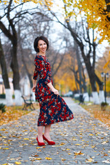 Beautiful elegant woman posing in a city street, autumn season