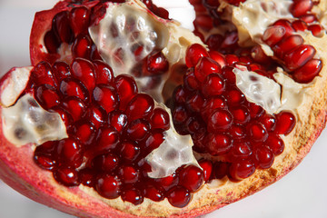 Ripe pomegranate closeup on a white background