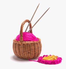 Fototapeta na wymiar a ball of yarn with spokes in a basket on a white background