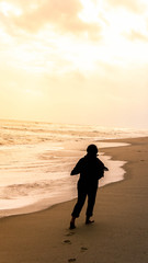Silhouette of an girl with hijab walking alone leaving her footprint on sand behind at the beach.