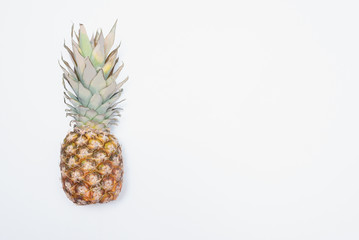 Pineapple on a white stone surface background with copy space.