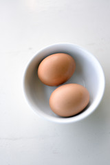 Eggs in white bowl ready to use. White background. Happy easter.