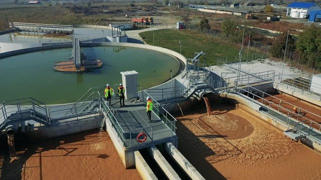 Engineers assessing waste water treatment plant with industrial drone