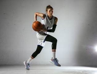 Young caucasian female basketball player of team in action, motion in jump isolated on white wall background. Concept of sport, movement, energy and dynamic, healthy lifestyle. Training, practicing. © master1305