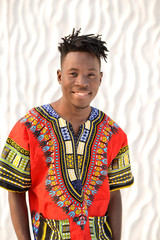 African American guy in national clothes on a background of a white wall