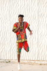 African American guy in national clothes on a background of a white wall