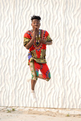 African American guy in national clothes on a background of a white wall