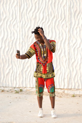 African American guy in national clothes on a background of a white wall