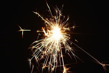 Christmas and New Year's illumination. Burning sparklers scatter bright exploding strips of sparks...