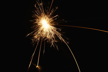 Christmas and New Year's illumination. Burning sparklers scatter bright exploding strips of sparks...