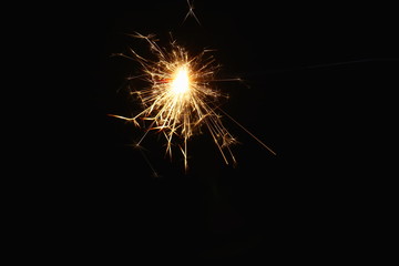 Christmas and New Year's illumination. Burning sparklers scatter bright exploding strips of sparks...