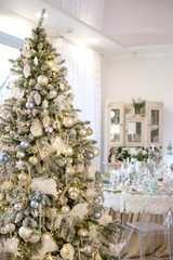 Christmas tree in white room decorated in retro style with white and blue balls
