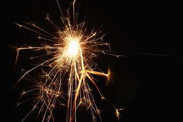 Christmas and New Year's illumination. Burning sparklers scatter bright exploding strips of sparks...