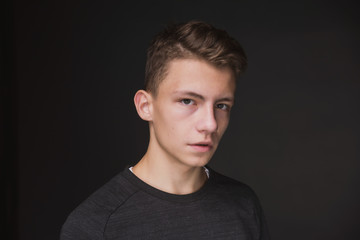 Fototapeta premium Beauty portrait of a beautiful young brown haired man on a gray background