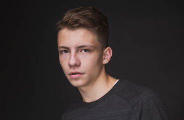 Beauty portrait of a beautiful young brown haired man on a gray background