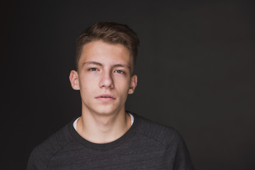 Beauty portrait of a beautiful young brown haired man on a gray background