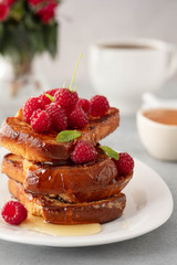 French toasts, French toasts made of sliced brioche with fresh raspberries, honey and mint. Delicious breakfast or dessert