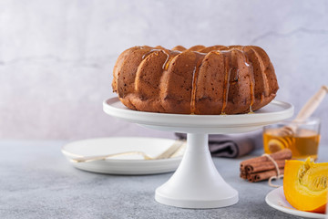 Pumpkin cake with honey on a gray background. Copy space.