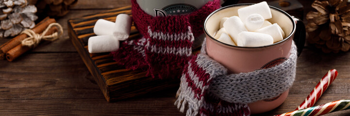 Christmas marshmallows and New Year decorations and sweet canes on a wooden background. Winter holidays, new year mood. Copy space. Close up. Banner.
