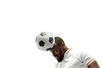 Close up of emotional african man playing soccer hitting the ball with the head on isolated white...