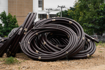 Black rubber or plastic pipes with a red lines as a construction material and equipment at building...