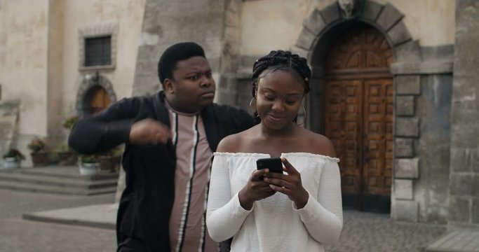 Girl ignoring boyfriend while using smarthone.