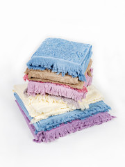 A stack of large and small towels on a light background, side view