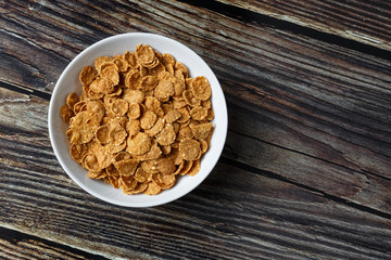 White plate with healthy cereal breakfast on a wooden surface. Top view.