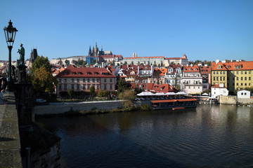 Fototapeta na wymiar ヴルタヴァ川の架かるカレル橋から見たプラハ城とカレル橋の彫刻