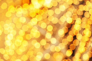 Golden Christmas light background with holiday glowing backdrop. Defocused glitter background with golden blinking stars