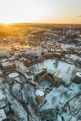 Aerial view of beautiful ruins of ancient Livonian castle in old town of Cesis, Latvia, covered in snow, winter morning sunrise time