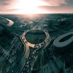 Busy roundabout at sunrise, Vilnius, Lithuania. Ring road traffic on rush hour - obrazy, fototapety, plakaty