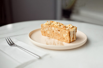 Coffee cake. A piece of cake on a plate. Sweet dessert on a round pink with a plate wooden background. Close-up.